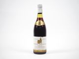 une bouteille de vin posée sur une table blanche