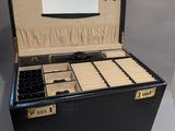 une boîte noire contenant un miroir et des bijoux