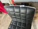 un fauteuil en cuir noir sur lequel est accrochée une étiquette de prix