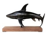 statue of a shark on a wooden base on a white background