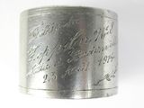 a silver ring with writing on it on a white surface