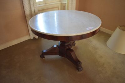 a round table with a marble top in the corner of a room