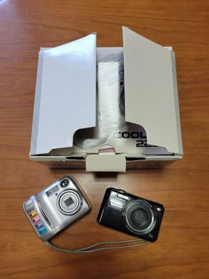a camera, a cell phone, and a box on a table