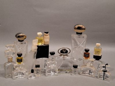 many bottles of perfume sitting on a white surface