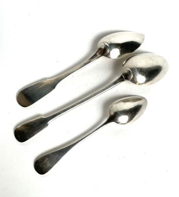 three silver spoons sitting on top of a table next to each other