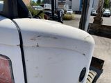 a close up of a white truck parked in a parking lot