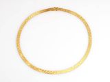 a close up of a gold necklace on a white surface