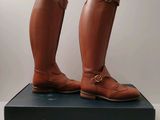 la paire de bottes marron est posée sur une boîte noire