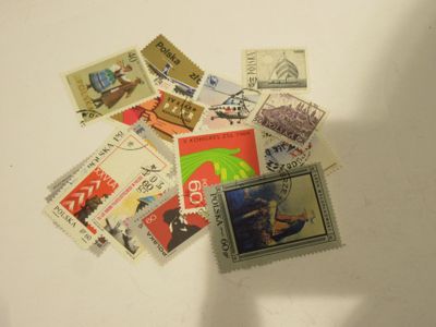 une pile de timbres posée sur une table, avec une personne tenant un téléphone portable