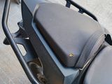a black motorcycle with a black seat and a black bag on the back