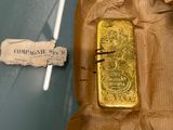 a gold bar on a piece of paper on a glass table