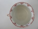 a white bowl with red flowers on it on a table
