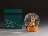 a snow globe sitting next to a box with a teddy bear inside of it