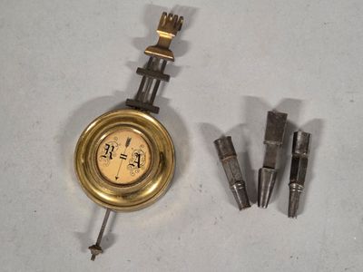 a clock that is sitting on a table next to some screws