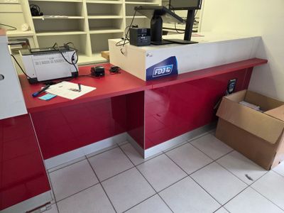 un bureau rouge sur lequel se trouvent une imprimante et une boîte