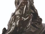 statue of a woman sitting on a book with a dog on her lap