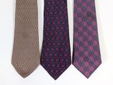 three ties are lined up on a white surface with a white wall behind them