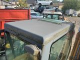 un camion qui est garé sur un terrain avec d'autres camions