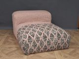 un repose-pieds rembourré orné d'un motif rose et gris
