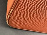 an orange louis vuitton suitcase sitting on top of a table