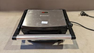 un gaufrier posé sur une table, à côté d'un cordon