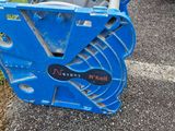 a blue cable reel sitting on the ground next to a car