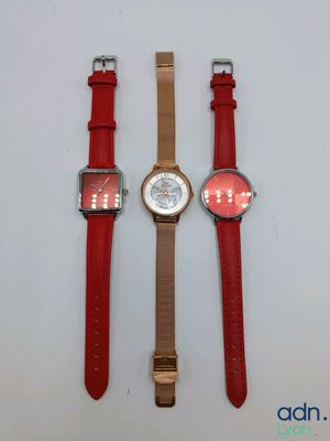 three different watches sitting on top of a white surface next to each other
