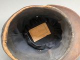 a brown hat with a wooden label on it