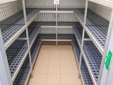 une longue étagère au milieu d'une pièce, avec des tablettes bleues