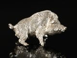 a silver figurine of a boar on a black surface