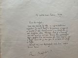 an old document with a handwritten letter on it sitting on top of a table