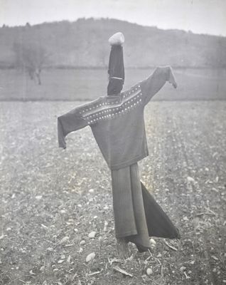 photographie en noir et blanc d'une femme debout dans un champ, tenant un foulard