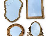 trois miroirs et un cadre de miroir posés sur une surface blanche