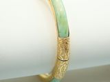 un gros plan d'une bague en or sertie de jade vert