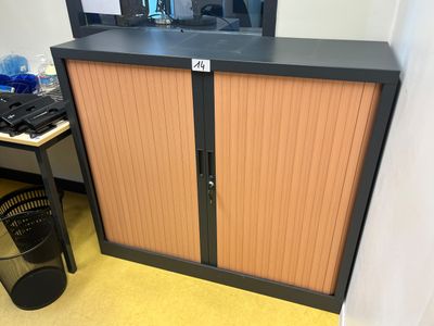une armoire avec une porte et une poubelle devant