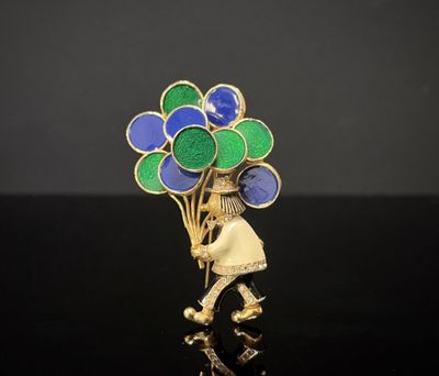 une broche plaquée or ornée de ballons bleus et verts
