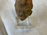 a figurine of a man ' s head on a clear base