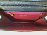 a black and red purse with a gold chain on it