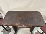 a small table with four stools and a table with a leather top