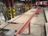 a long red bench in a warehouse with lots of wooden planks