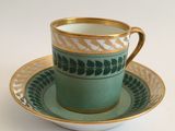 a tea cup and saucer on a white table