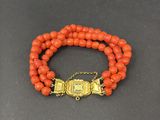 un bracelet en perles orange avec un fermoir doré