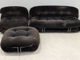 three black chairs and a ottoman in a white room
