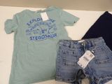 two pairs of shorts and a t - shirt are on a table