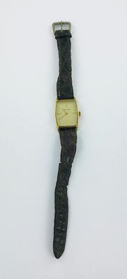 une photo d'une montre posée sur une surface blanche