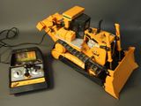 a toy bulldozer next to a remote control