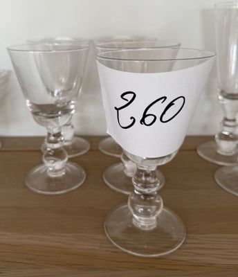 six verres à vin posés sur une table, chacun portant un numéro