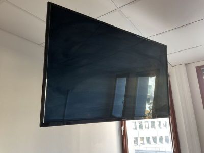 une télévision à écran plat suspendue au plafond dans une pièce