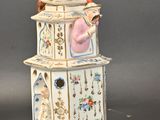 a white clock tower with a woman on it