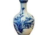 un vase bleu et blanc posé sur une surface blanche